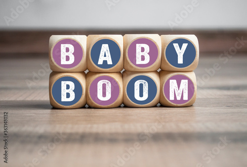 Wall made of cubes and dice with word baby boom on wooden background