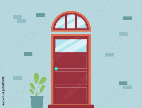 Red front entry door with arched transom window on blue wall with house plant