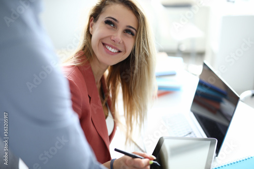 Business woman in office puts an electronic signature on tablet. Development and support of small and medium business concept