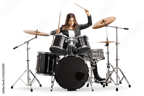 Young female drummer playing drums with drumsticks