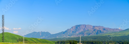 阿蘇山への道 美しい晴天と青空を背景に阿蘇山道の山々風景 新緑と初夏の季節 パノラマ撮影 Road to Mount Aso Mountain scenery of Aso mountain road against the background of beautiful clear sky and blue sky Fresh green and early summer season Pano