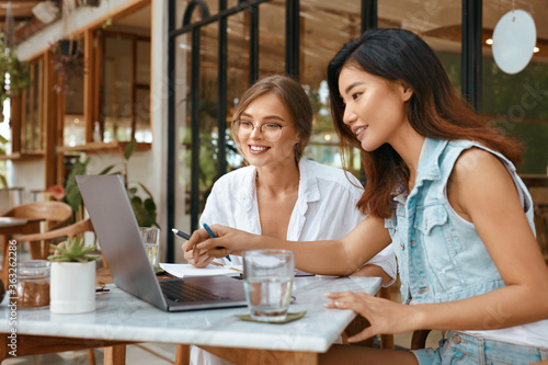 Meeting At Cafe. Women With Laptop Using Digital Technologies For Chatting With Team. Comfortable Collaboration With Colleagues On Summer Vacation. Online Job For Successful Business. 