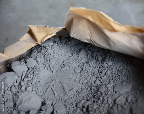 Close up trowel and cement powder in paper bag.