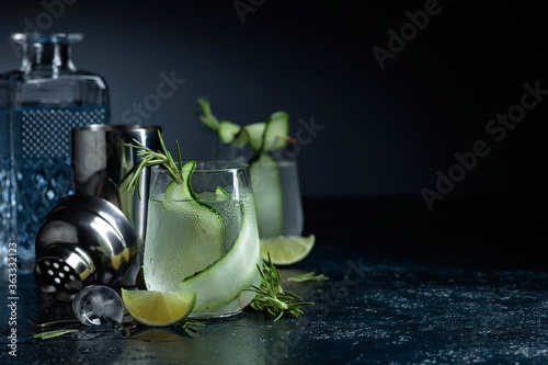 Gin tonic with rosemary, lime and cucumber in frosted glass.