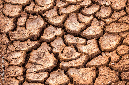 Horizontal background of the desiccation cracks in dry earth. A drought or drouth is a natural disaster of below-average precipitation in a given region.