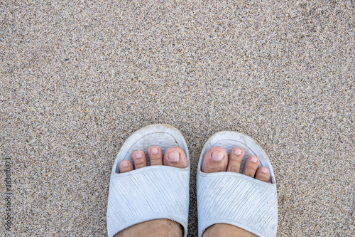 Feet on the sand of a beach.