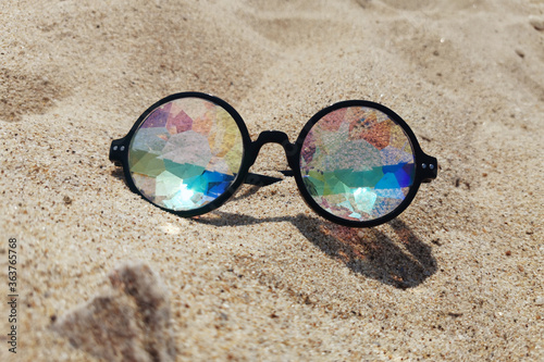 designer glasses with lenses kaleidoscope in the sand