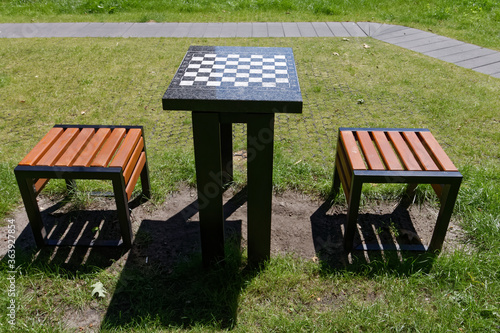 Stolik do szachów w parku i dwa siedzenia