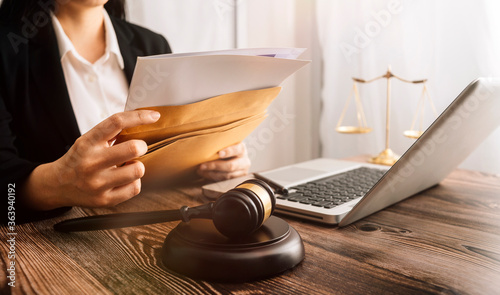 Business and lawyers discussing contract papers with brass scale on desk in office. Law, legal services, advice, justice and law concept