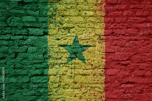 painted big national flag of senegal on a massive old brick wall