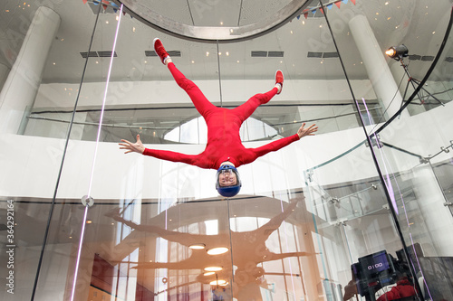 levitation of sports people in a wind tunnel. jumping without a parachute in a wind tunnel indoors. Man in a red suit, portrait of a skydiver, flies head down. extreme sport