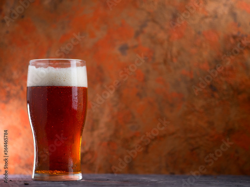 A glass of beer red ale on a concrete background