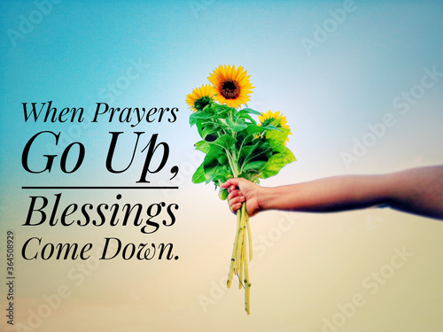 Inspirational quote - When prayers go up, blessings come down. With hand holding bouquet of sunflowers against bright blue sky background. Prayer and blessing text message concept.