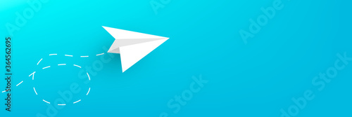 Paper plane on a blue horizontal background copy space.