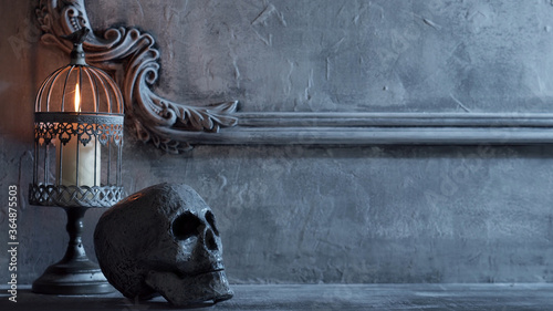 Mystical Halloween still-life background. Skull, candlestick with candles, old fireplace. Horror and witchery.