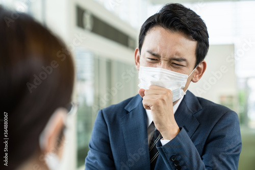 会話中に咳をするビジネスマン