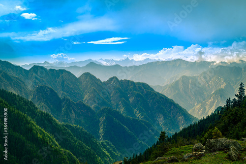 Mountain landscape with clouds, meadows. Himalayas peaks & alpine l from the trail of Sar Pass trek Himalayan region of Kasol, Himachal Pradesh, India.