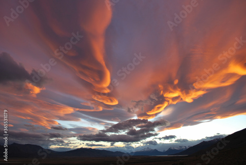 Cielo dramático con nubes lenticulares anaranjadas al atardecer en Patagonia.