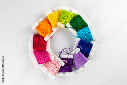 Top down photo of a rainbow assortment of embroidery thread on bobbins