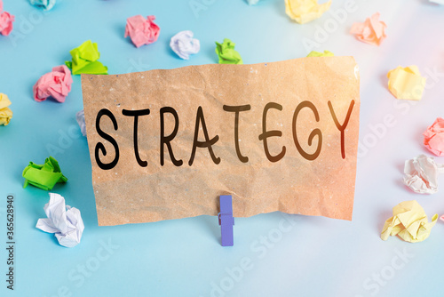 Text sign showing Strategy. Business photo text action plan or strategy designed to achieve an overall goal Colored crumpled papers empty reminder blue floor background clothespin