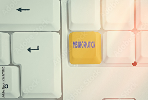 Writing note showing Misinformation. Business concept for false data, in particular, intended intentionally to deceive Colored keyboard key with accessories arranged on empty copy space