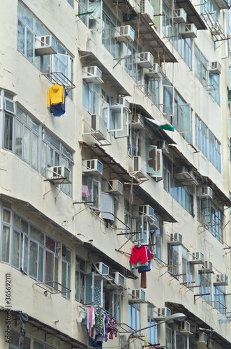 Triste Fassade eines Hochhauses in Hongkong mit Klimaanlagen und frisch gewaschener Wäsche