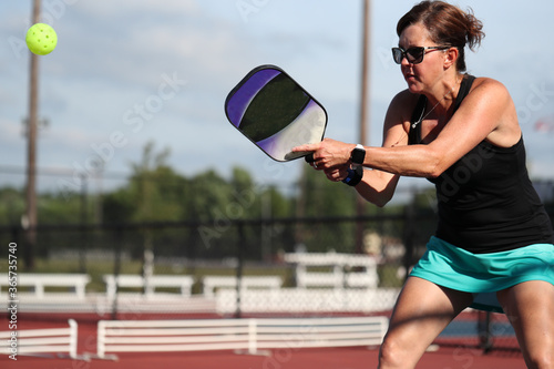 A two handed backhand is hit during a pickleball match