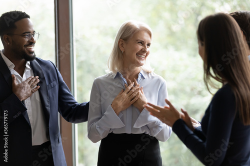 60s businesswoman staff member get praises congrats cheers compliments from multi ethnic colleagues. Promotion career advance, life events birthday celebration, warm relation, kindness from teammates