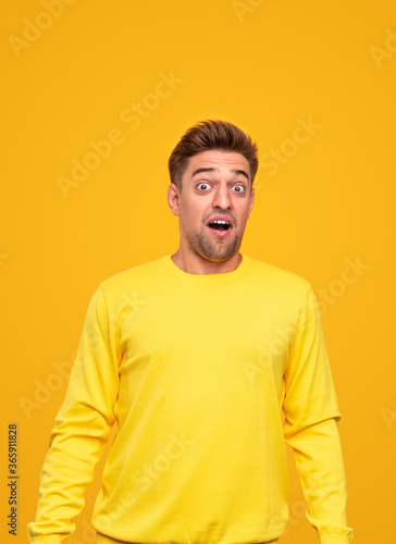 Surprised young man in yellow clothes