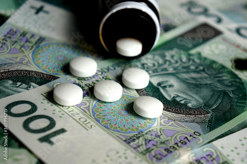 Polish banknotes (PLN) and pills - healthcare cost concept