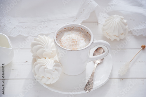 Coffee and marshmallow on a white wooden background