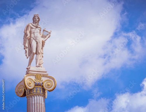 Apollo, the ancient Greek god of arts under impressive sky, Athens Greece