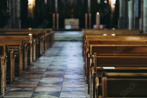 Passage d'une église avec des bancs en bois vide et une lumière latérale