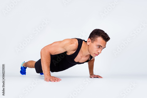 Portrait of his he nice attractive content sportive strong macho dedicated guy doing exercise push-ups motivation goal isolated over light gray pastel color background