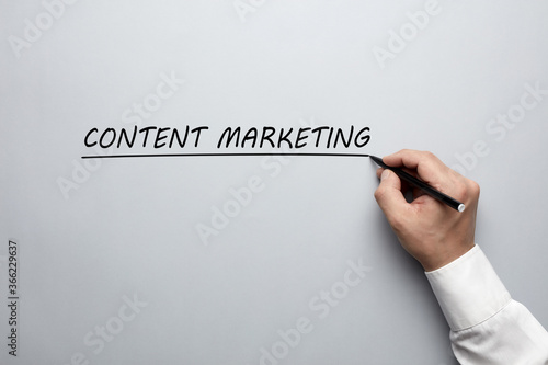 Businessman hand writing the words content marketing. Concept of content marketing training.
