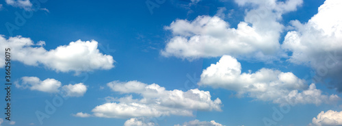 Wide banner with blue sky and white clouds.