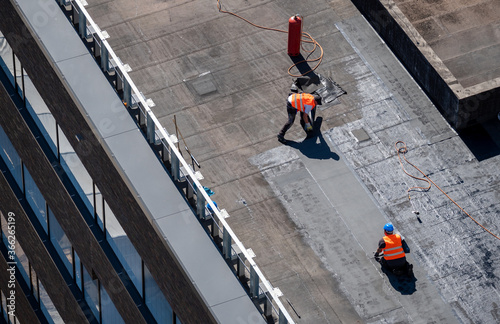 Birds eye view of a roof construction site. Professional bitumen waterproofing on a flat building.