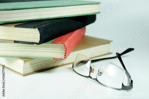 A pile of books and a pair of glasses symbolizing the concept of reading habit