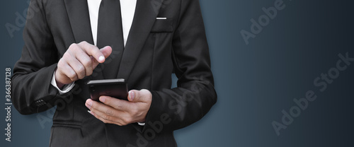 Closeup image of businessman holding and using mobile phone with copy space. Idea for business, technology and online marketing.