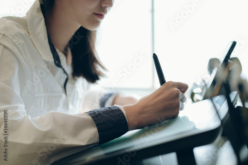Graphic designer using graphic tablet at desk in the office