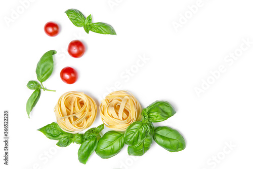 Frame of cherry tomatoes, pasta and basil leaves on a white isolated background. Fresh food. Flat lay. Copy space.