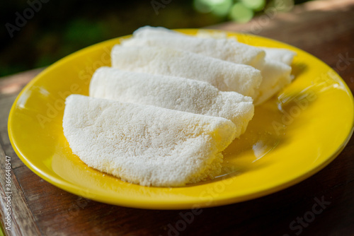 Butter and cheese tapioca served on a yellow plate.