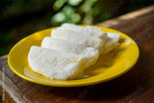 Butter and cheese tapioca served on a yellow plate.