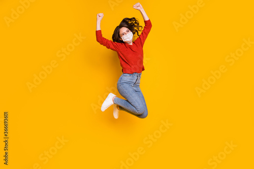 Full length body size view of her she nice attractive lovely wavy-haired girl jumping wearing gauze mask rejoicing win winner isolated on bright vivid shine vibrant yellow color background