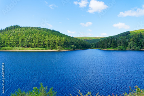 Across the breadth of Derwent Upper Reservoir to the wooded hills of the Derbyshire countryside