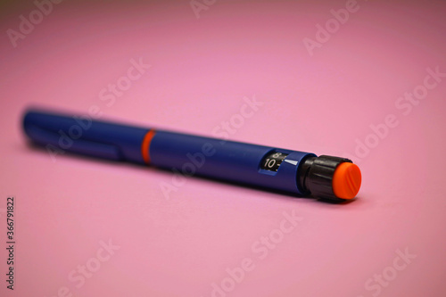 insulin pen, injector pen on a pink background. used to treat diabetes in insulin pens. Close-up, macro. selective focus.