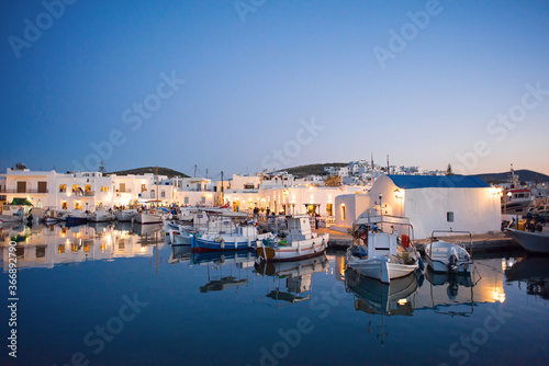 Traditional greek fishing village in Paros island, Greece. Beautiful sunset view of Naoussa, Cyclades. Popular tourist destination in Europe