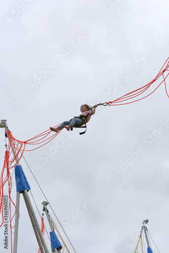 young girl jumping hanging on a rubber band