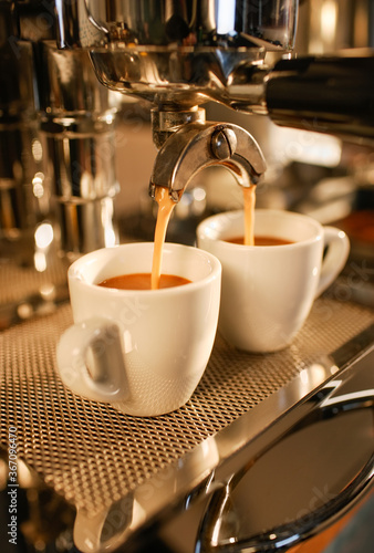 Zwei Espresso Tassen unter einer Espresso Maschine 