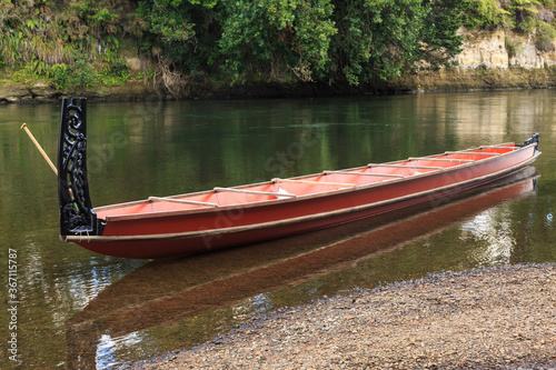 A Maori waka (canoe) with ornamental carvings on the stern post in the Waikato River, New Zealand